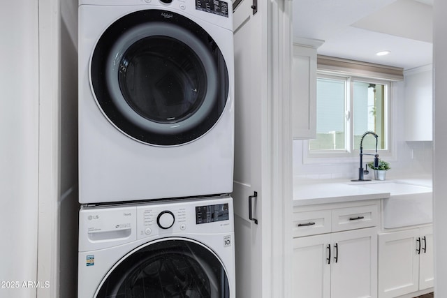 laundry room featuring stacked washer and dryer, laundry area, and a sink