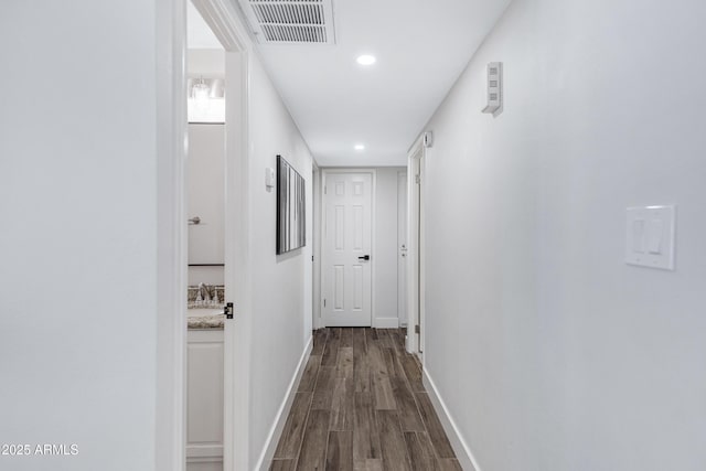 hallway with recessed lighting, dark wood-style flooring, visible vents, and baseboards