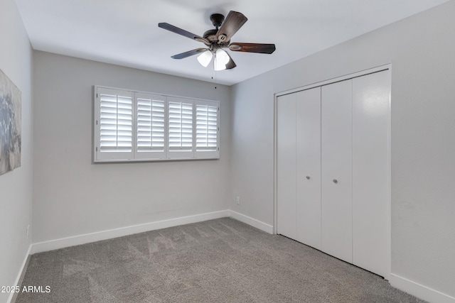 unfurnished bedroom featuring a closet, carpet flooring, a ceiling fan, and baseboards