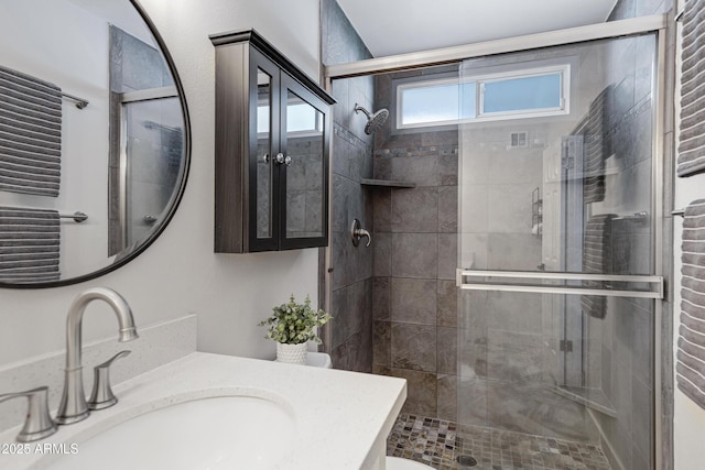 bathroom featuring a shower stall and vanity