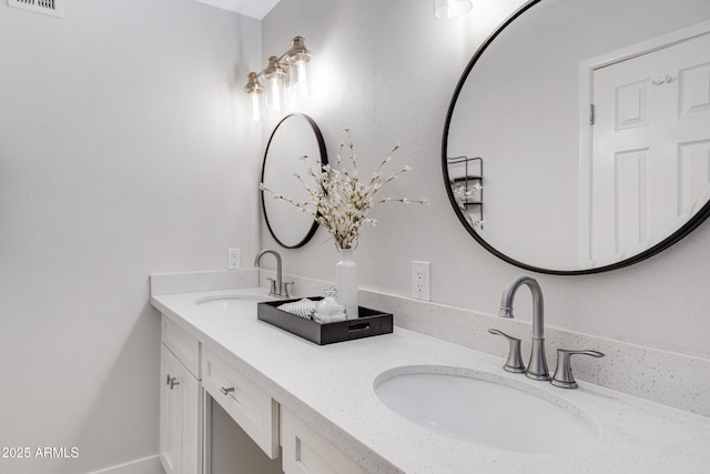 bathroom with visible vents, a sink, and double vanity