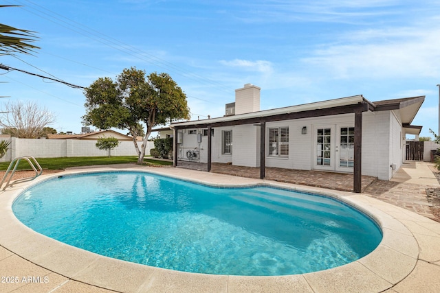 view of swimming pool with french doors, a patio area, a fenced backyard, and a fenced in pool