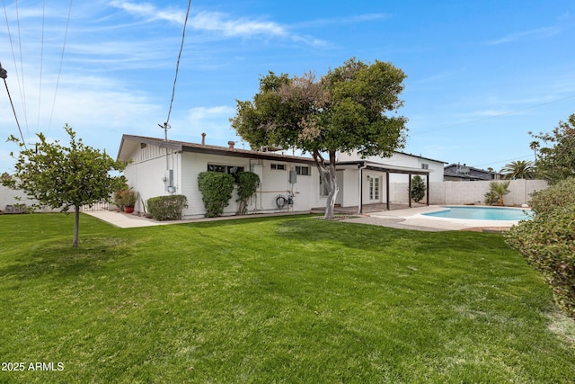 back of house featuring a patio area, fence, a fenced in pool, and a yard