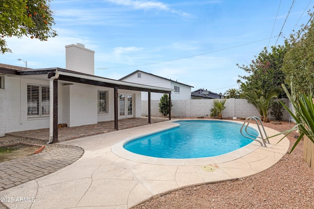 view of swimming pool with french doors, a patio area, a fenced backyard, and a fenced in pool