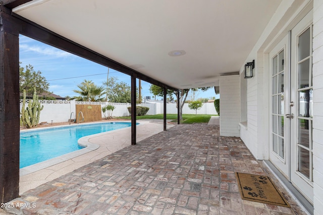 view of swimming pool with a fenced in pool, a patio area, french doors, and a fenced backyard