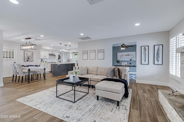 living area featuring visible vents, baseboards, light wood-style flooring, ceiling fan, and recessed lighting