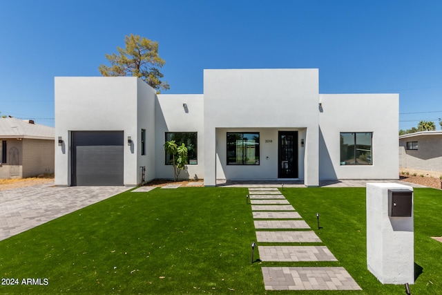 view of front of property featuring a garage and a front lawn