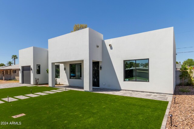 view of front of house featuring a garage and a front yard