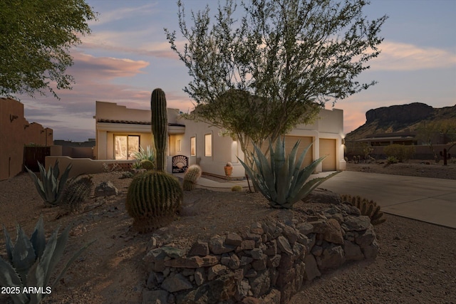 pueblo-style home with concrete driveway and stucco siding