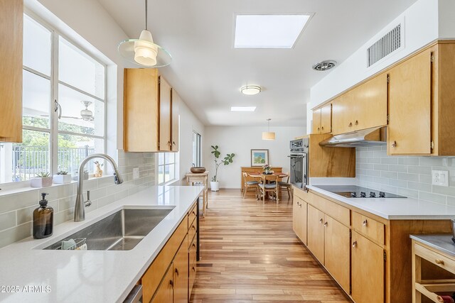 314 E Royal Palm Rd, Phoenix, AZ 85020 - kitchen featuring under cabinet range hood, oven, light wood-style flooring, and decorative backsplash