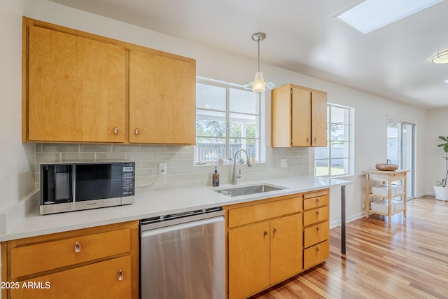 314 E Royal Palm Rd, Phoenix, AZ 85020 - kitchen with stainless steel appliances, tasteful backsplash, light wood-style flooring, light countertops, and decorative light fixtures
