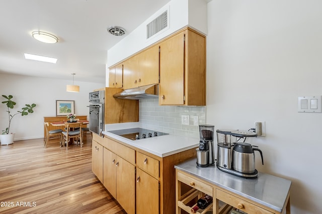 314 E Royal Palm Rd, Phoenix, AZ 85020 - kitchen with oven, black electric stovetop, under cabinet range hood, tasteful backsplash, and light wood-style flooring