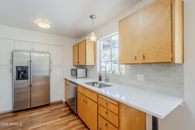 314 E Royal Palm Rd, Phoenix, AZ 85020 - kitchen with stainless steel appliances, tasteful backsplash, light countertops, light wood-type flooring, and hanging light fixtures