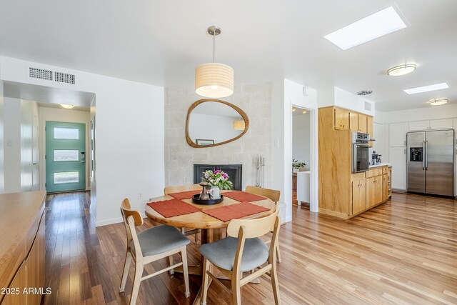 314 E Royal Palm Rd, Phoenix, AZ 85020 - dining area with light wood-style floors, a fireplace, and a skylight