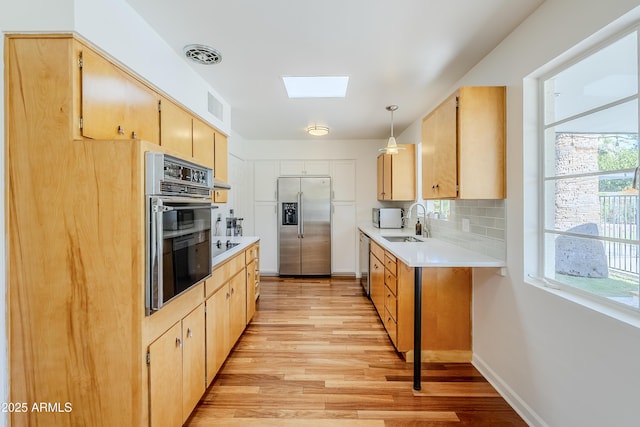 314 E Royal Palm Rd, Phoenix, AZ 85020 - kitchen featuring black appliances, a skylight, light wood-style flooring, and light brown cabinets