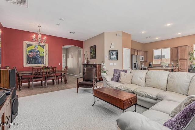 12417 W Apache St, Avondale, AZ 85323 - living room with arched walkways, a chandelier, recessed lighting, and light carpet