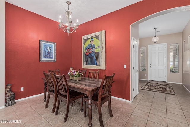 12417 W Apache St, Avondale, AZ 85323 - dining space with arched walkways, light tile patterned floors, a chandelier, and baseboards