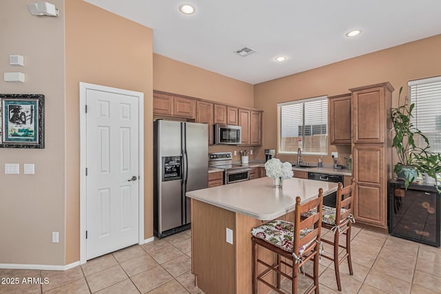 12417 W Apache St, Avondale, AZ 85323 - kitchen with stainless steel appliances, a breakfast bar area, light tile patterned floors, light countertops, and recessed lighting