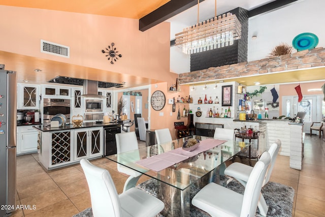 tiled dining area with beam ceiling, wine cooler, and high vaulted ceiling