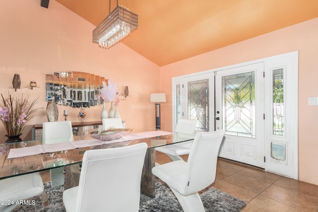 dining space featuring high vaulted ceiling, tile patterned floors, and a notable chandelier