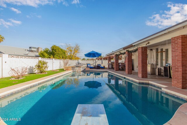 view of swimming pool with a diving board and a patio area