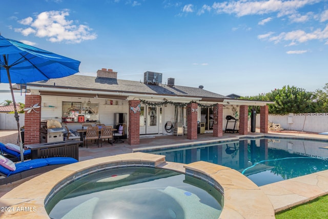 view of pool featuring an in ground hot tub, cooling unit, and a patio area