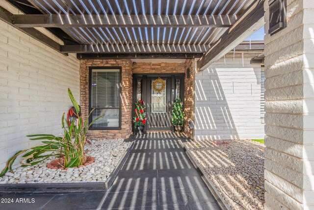 property entrance with a pergola