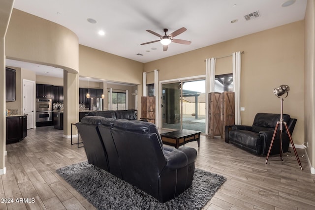 living room featuring ceiling fan and light hardwood / wood-style floors