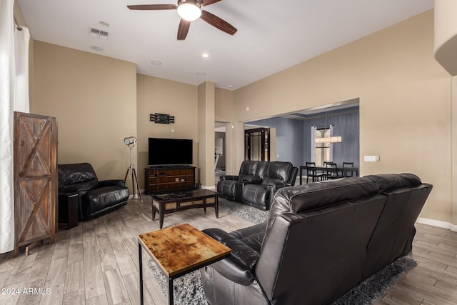 living room featuring light hardwood / wood-style flooring and ceiling fan