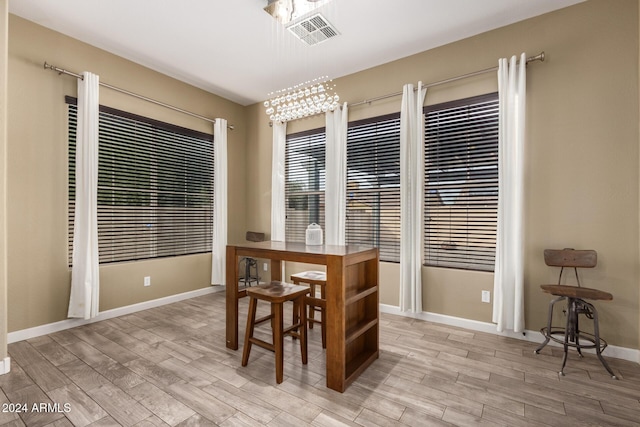 dining area featuring light wood-type flooring and an inviting chandelier