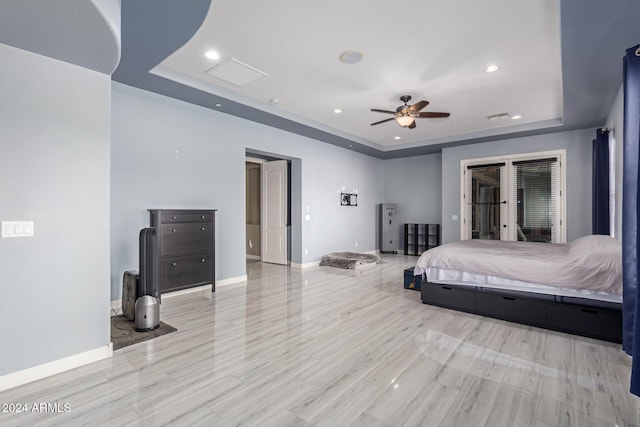 bedroom with access to exterior, french doors, a raised ceiling, and ceiling fan