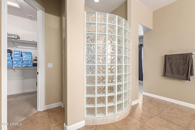 bathroom with tile patterned flooring and walk in shower