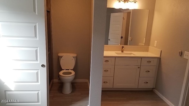 bathroom with vanity, wood-type flooring, and toilet