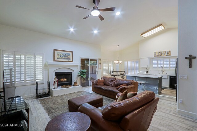 living room featuring a fireplace, light hardwood / wood-style flooring, a wealth of natural light, and sink