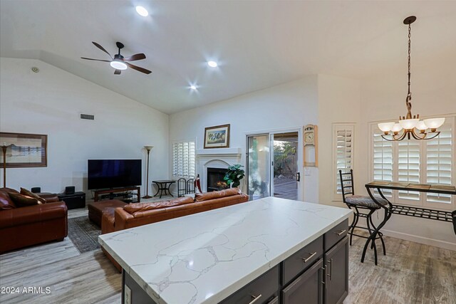 kitchen with light hardwood / wood-style flooring, a center island, pendant lighting, and lofted ceiling