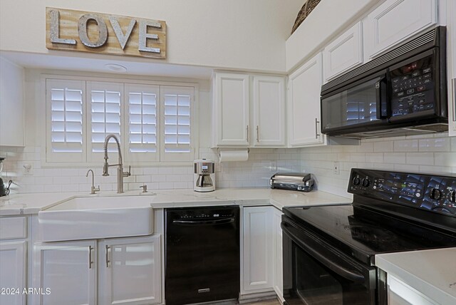 kitchen featuring tasteful backsplash, white cabinetry, sink, and black appliances