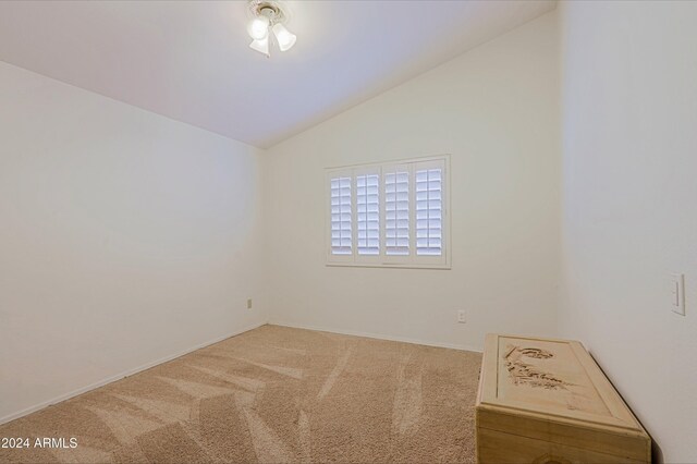 carpeted spare room featuring lofted ceiling