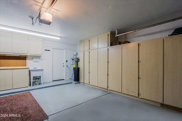 garage featuring a garage door opener and water heater