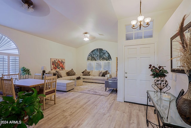 foyer entrance with ceiling fan with notable chandelier, light hardwood / wood-style floors, and lofted ceiling