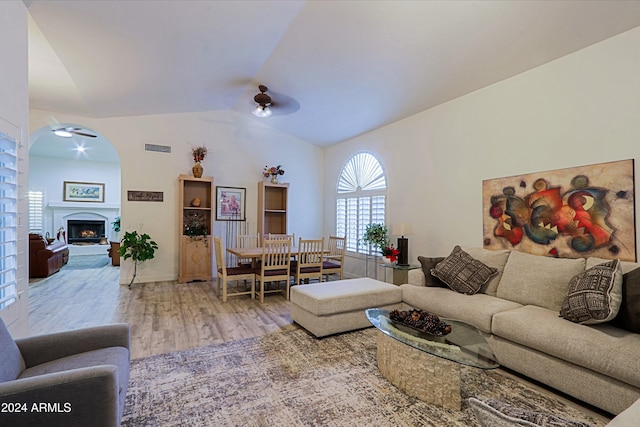 living room with hardwood / wood-style floors, ceiling fan, and lofted ceiling