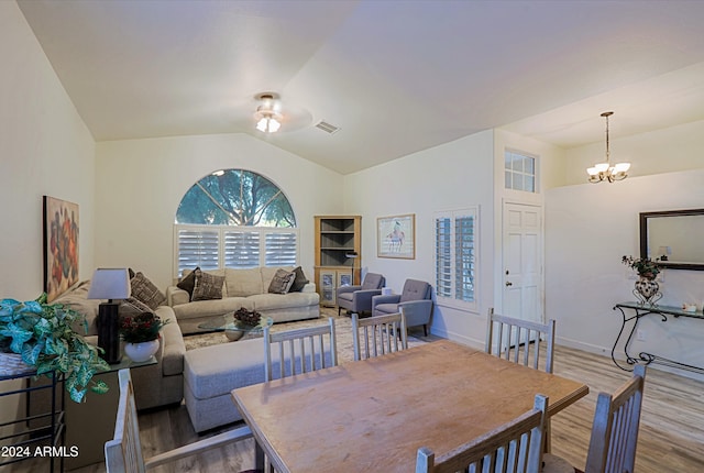 dining area with light hardwood / wood-style flooring, a chandelier, and vaulted ceiling