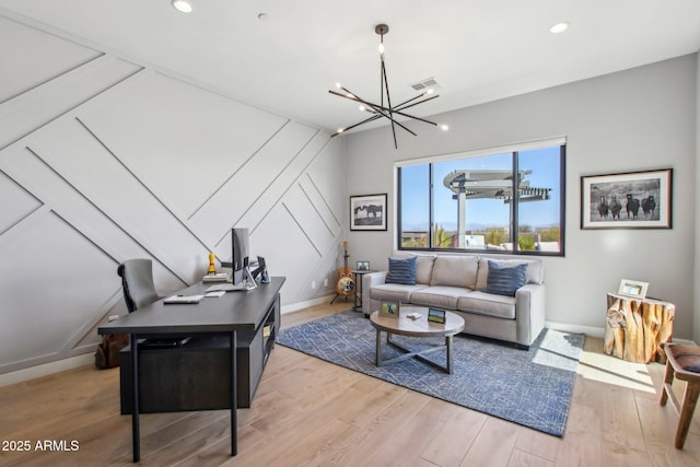 living room featuring light wood finished floors, recessed lighting, baseboards, and an inviting chandelier