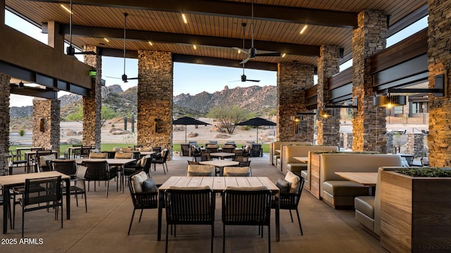 view of patio featuring outdoor dining space, an outdoor living space, a mountain view, and ceiling fan