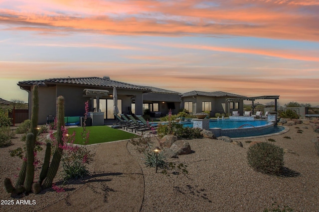 back of property at dusk featuring a tiled roof, stucco siding, an outdoor pool, a pergola, and a patio