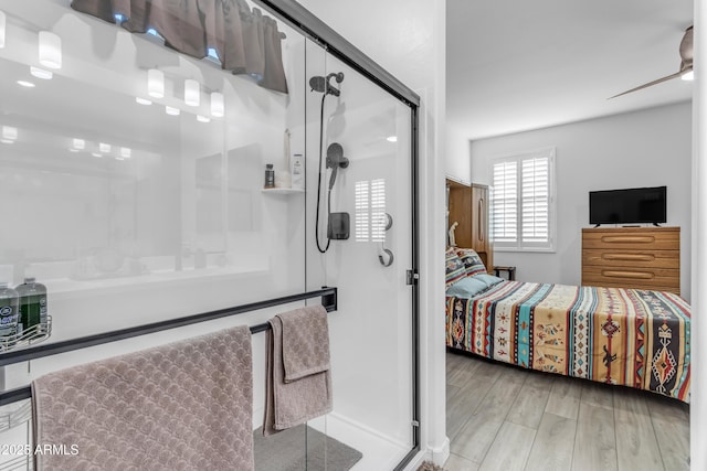 bathroom featuring hardwood / wood-style floors, a shower with door, and ceiling fan