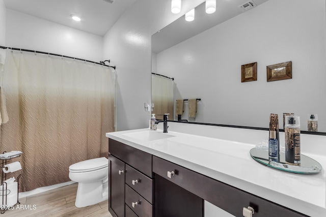 bathroom featuring vanity, wood-type flooring, and toilet