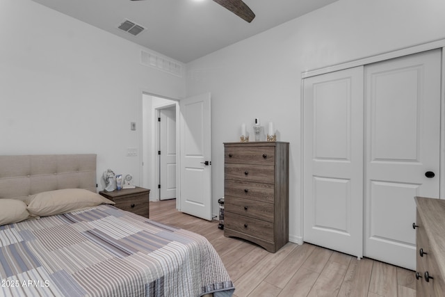 bedroom with light hardwood / wood-style floors, ceiling fan, and a closet