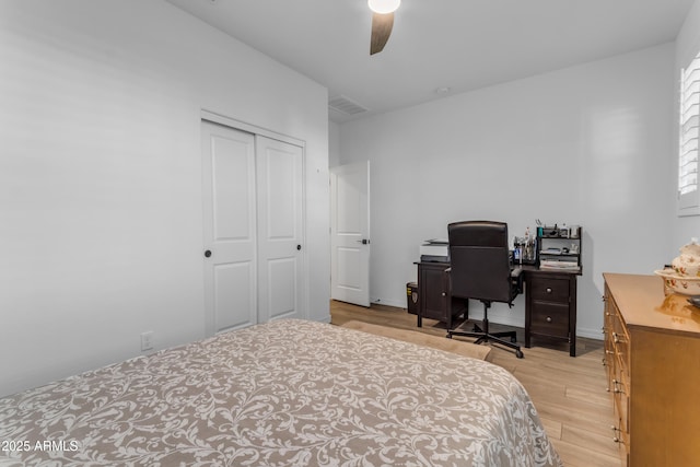 bedroom with light hardwood / wood-style floors, a closet, and ceiling fan