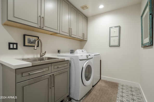 clothes washing area with cabinets, independent washer and dryer, light tile patterned floors, and sink