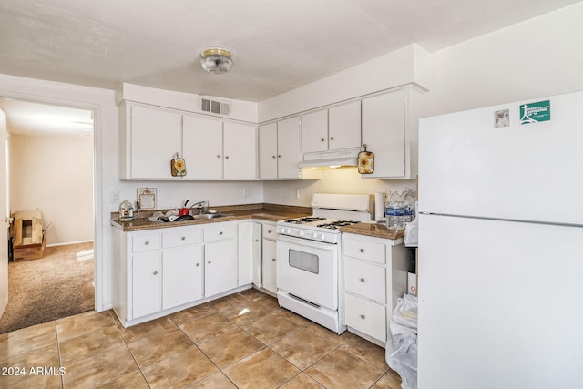 kitchen with white appliances, light carpet, sink, and white cabinets